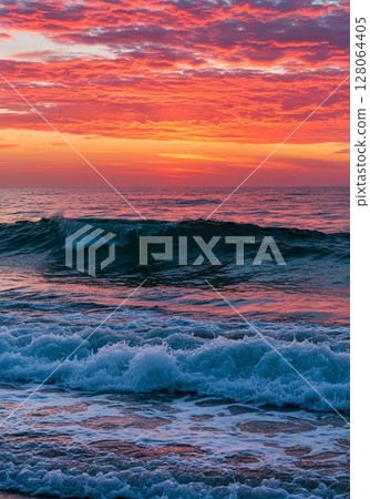 Vibrant Pink And Orange Sunrise Over Calm Ocean Waves 128064405