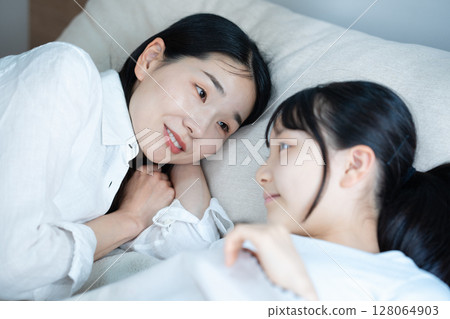 Mom sleeping with her daughter 128064903