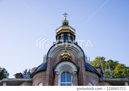 Restoration of a historic church highlights its golden dome under clear blue skies, showcasing intricate architecture and craftsmanship Restoration of a historic church highlights its golden dome under clear blue skies, showcasing intricate architecture and craftsmanship 128065721
