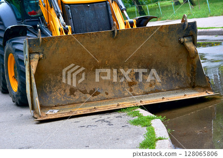 City break.Bulldozer with a large bucket on road City break.Bulldozer with a large bucket on road 128065806
