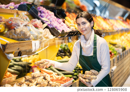 Woman seller laying out ginger on the counter 128065908