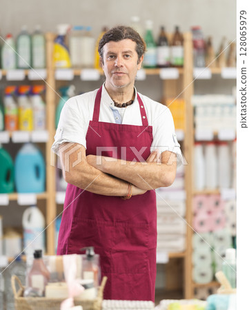Man seller in apron invite and working in households store 128065979