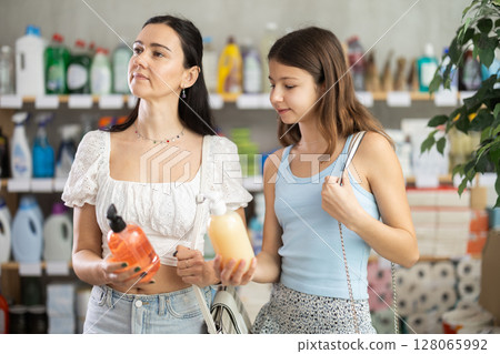 Mom and daughter in summer clothes choosing hand soap in store Mom and daughter in summer clothes choosing hand soap in store 128065992