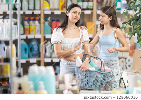 Tired mom saying no while girl keeping insisting in store Tired mom saying no while girl keeping insisting in store 128066010