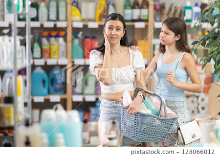 Tired mother with capricious daughter in household chemicals store Tired mother with capricious daughter in household chemicals store 128066012