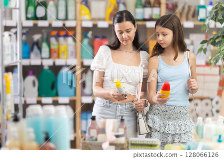 Woman with teen daughter choosing insect repellents in household store Woman with teen daughter choosing insect repellents in household store 128066126
