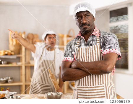 Upset African baker reprimanded by boss in small bakery Upset African baker reprimanded by boss in small bakery 128066189