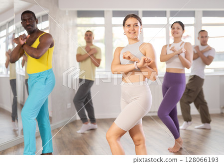 Active female Hip-hop dancers exercising dance moves in studio with multinational group 128066193