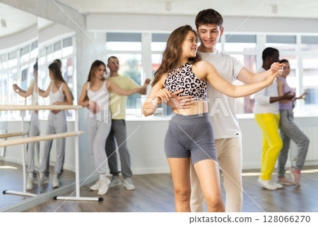Ordinary adults dancing bachata together in dance studio Ordinary adults dancing bachata together in dance studio 128066270