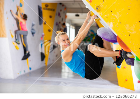 Woman exercising in climbing gym Woman exercising in climbing gym 128066278