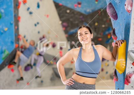 Young woman posing on climbing wall Young woman posing on climbing wall 128066285