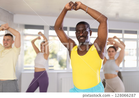 African american fitness trainer leading dynamic zumba class African american fitness trainer leading dynamic zumba class 128066287