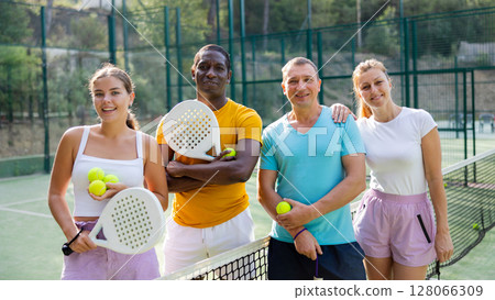 Two pairs of padel players are happily discussing past game on an open court 128066309