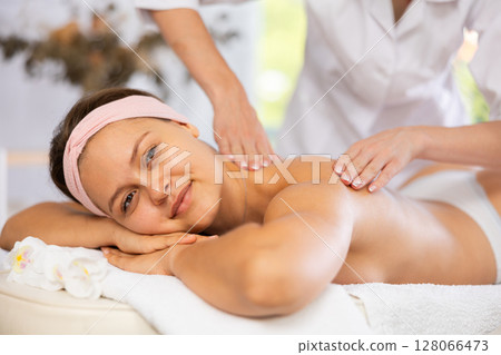 Young woman enjoying Swedish back and shoulders massage Young woman enjoying Swedish back and shoulders massage 128066473