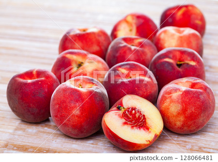 Sweet juicy peaches fruit on wooden surface close up Sweet juicy peaches fruit on wooden surface close up 128066481