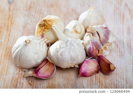 Image of fresh garlic on wooden surface 128066494