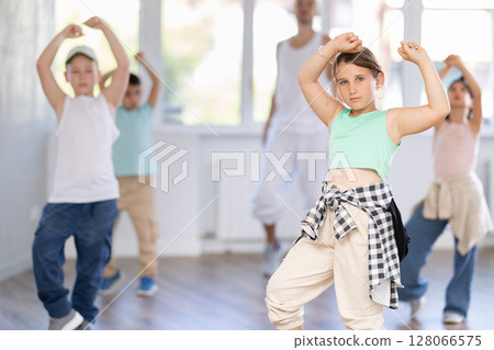 Girls and boys training hip hop in dance studio, dance classes for kids Girls and boys training hip hop in dance studio, dance classes for kids 128066575