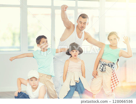 Preteen children posing with dance instructor in hip-hop studio 128066586
