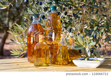 Various kinds of oil on the table on background of olive tree 128066722