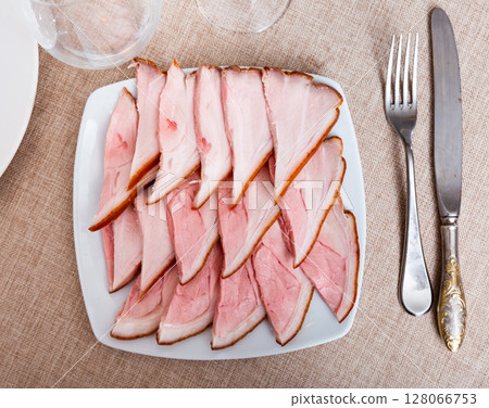 Plate is filled with slices of smoked meat fore shank. Plate is filled with slices of smoked meat fore shank. 128066753