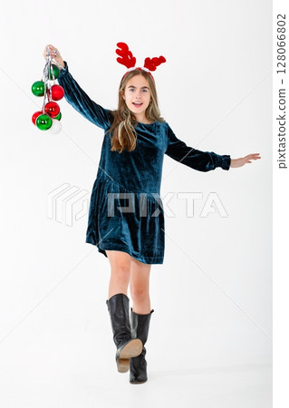 Merry Christmas cute girl reindeer antlers holding Christmas decorations isolated white background Merry Christmas cute girl reindeer antlers holding Christmas decorations isolated white background 128066802