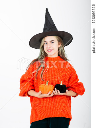 Portrait smiling girl in witch black hat, with pumpkin jack sweet candy. Isolated white background 128066816