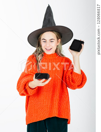 Portrait smiling girl in witch black hat, with pumpkin jack sweet candy. Isolated white background 128066817