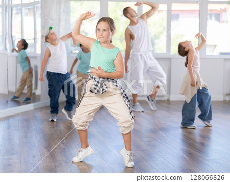 Girls and boys performing hip hop dance training hall during group dancing classes Girls and boys performing hip hop dance training hall during group dancing classes 128066826