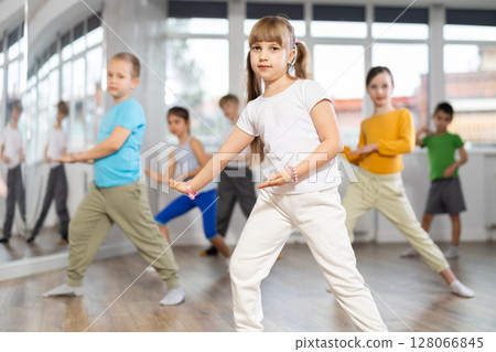 Children studying modern style dances with female teacher in dance class 128066845