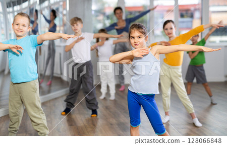 Girl learn to dance modern dances, doing movement with unrecognizable teacher. 128066848