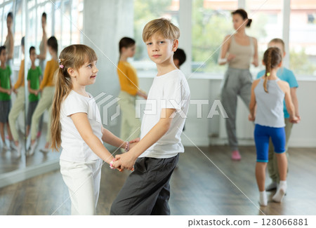 Girl paired up with boy and training to perform slow couple dance, rehearse performance. 128066881