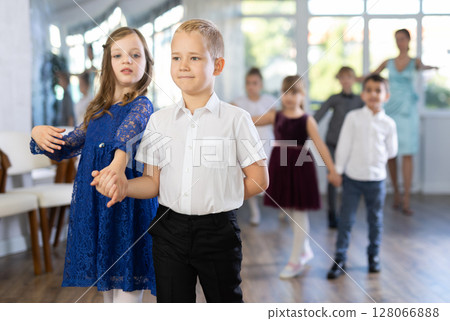 Group of preteen children movements of waltz in dance studio Group of preteen children movements of waltz in dance studio 128066888