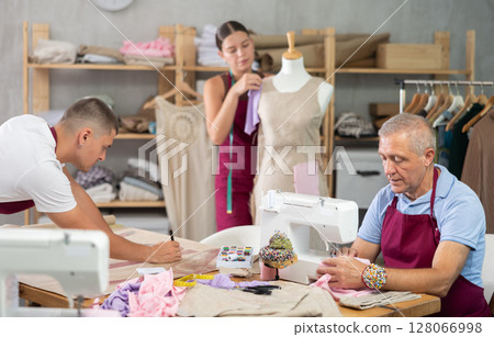 Senior man employee sewing, stitch clothes, girl work with mannequin, guy draw dress pattern 128066998