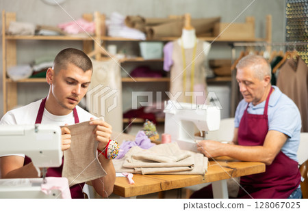 Two male tailors working with fabric 128067025
