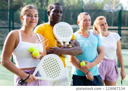 Two pairs of padel players are happily discussing past game on an open court 128067134