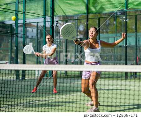 Two women tennis players playing padel 128067171