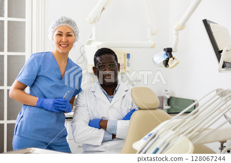 Portrait of smiling dentist and assistant in office of dental clinic 128067244