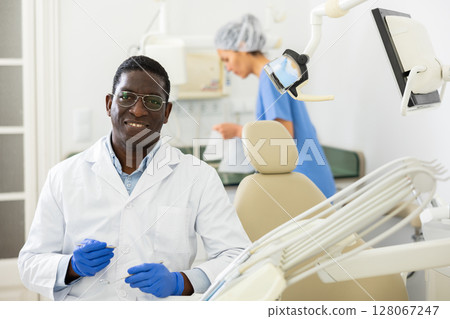 Smiling african american dentist posing in dental clinic office 128067247