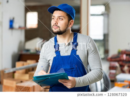Qualified builder writes notes on a tablet 128067320