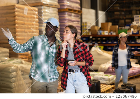 Man and woman working in warehouse, talking about job Man and woman working in warehouse, talking about job 128067480