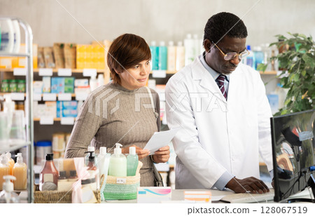 Man pharmacist looking for prescription on computer for buyer 128067519
