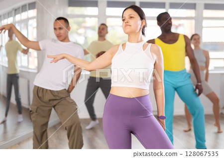 Asian girl with team of like-minded multinational people learn to elements of hip hop dance 128067535