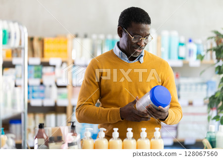 African American man choosing infant formula in pharmacy 128067560