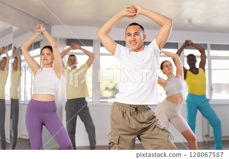 Young Asian male instructor leading modern dance class 128067587