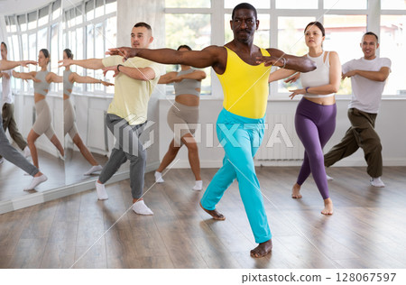African man with team of like-minded multinational people learn to elements of Vogue dance 128067597