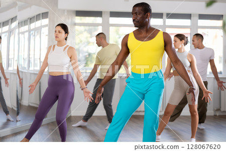 Positive black man participating in group Latin dance class 128067620