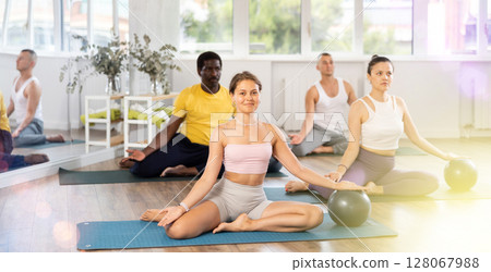 Group of men and women doing pilates with softball Group of men and women doing pilates with softball 128067988