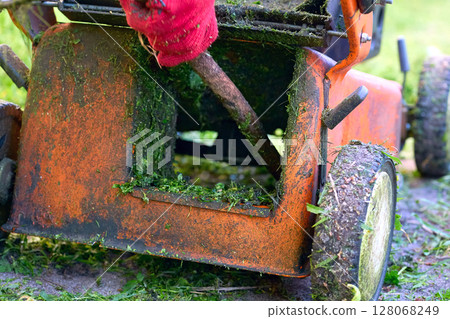 Cleaning up mown grass handle lawn mower.Professional grass cutting 128068249