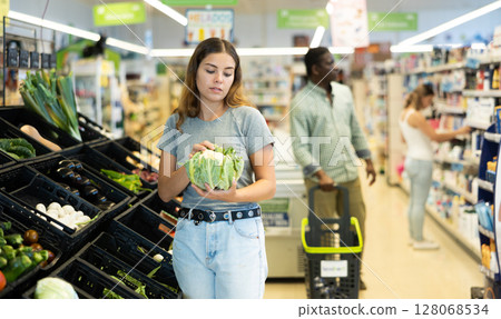 Young girl buying cauliflower at market 128068534