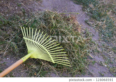 Green plastic mop sweeping trash in the yard Green plastic mop sweeping trash in the yard 128068591